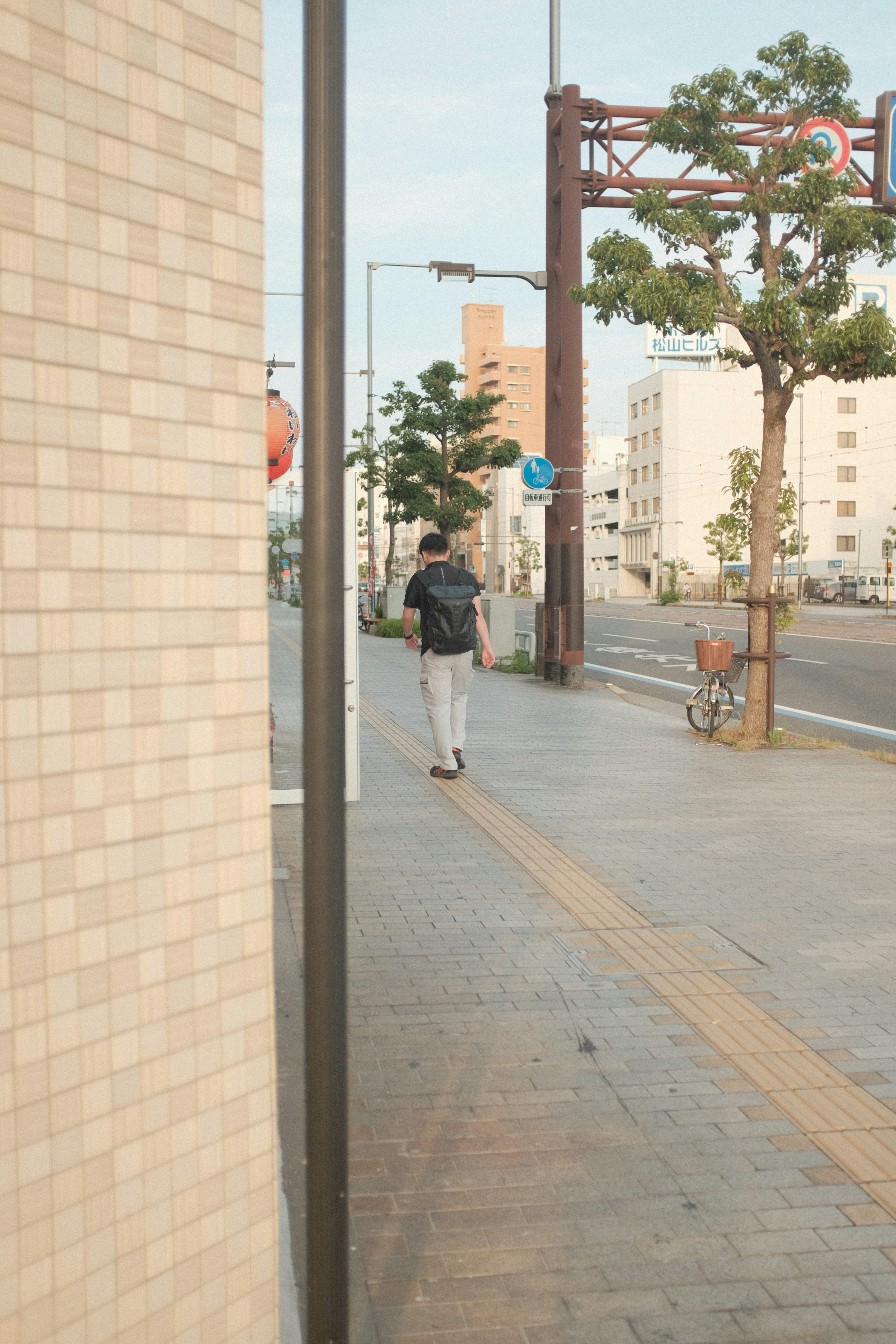 man in black jacket walking on sidewalk during daytime